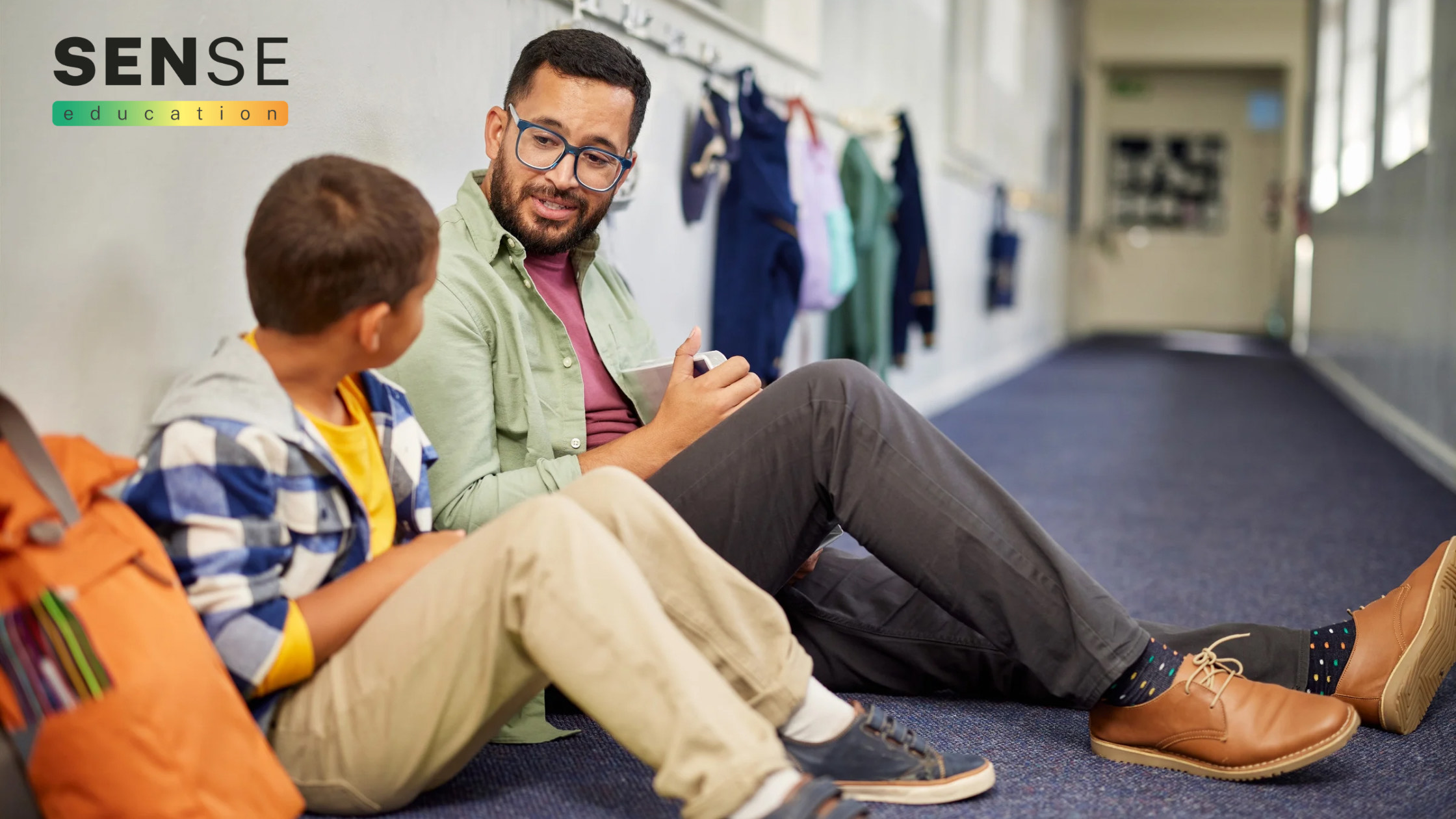 Child in school sharing thoughts with male teacher