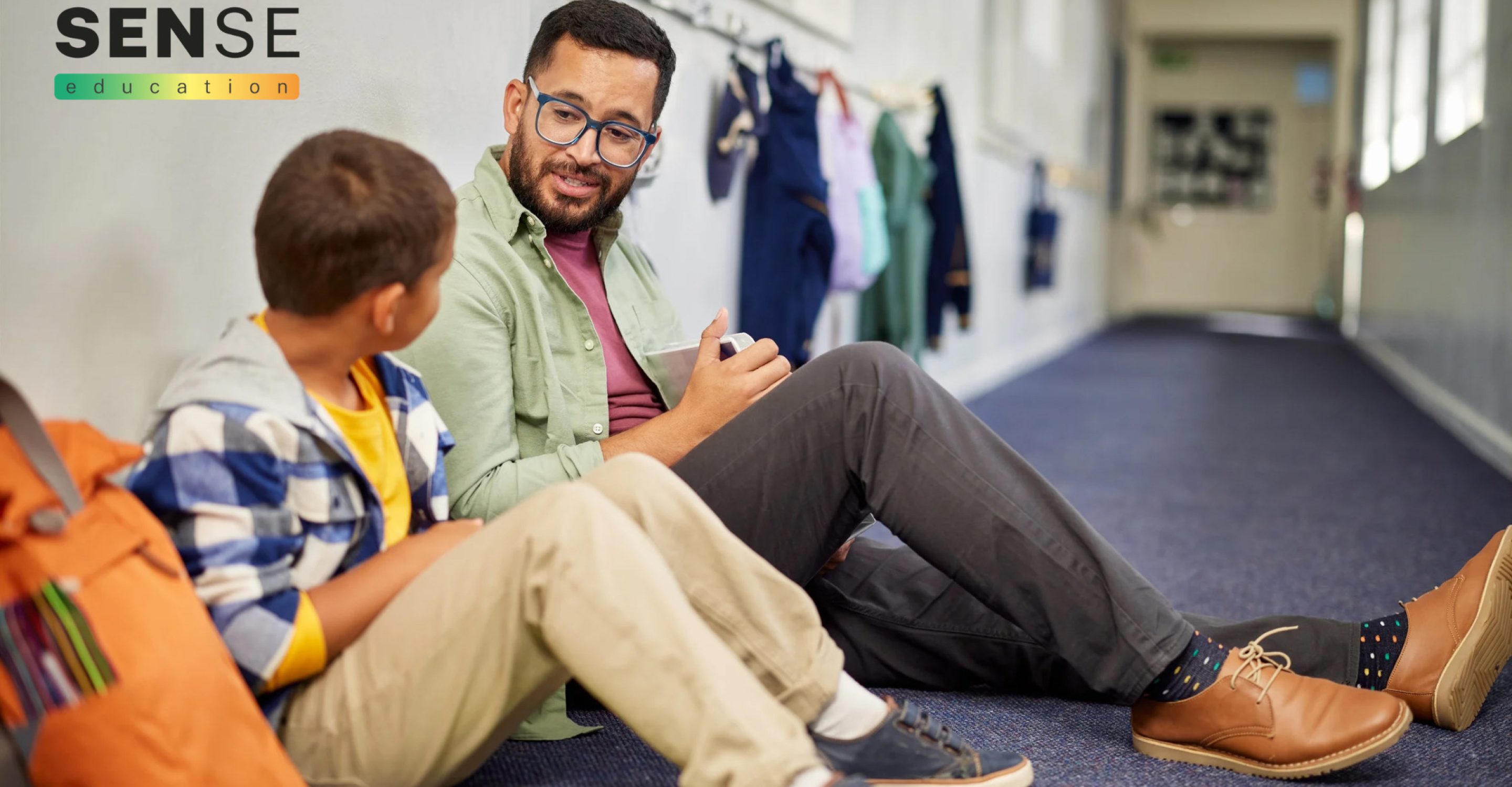 Child in school sharing thoughts with male teacher